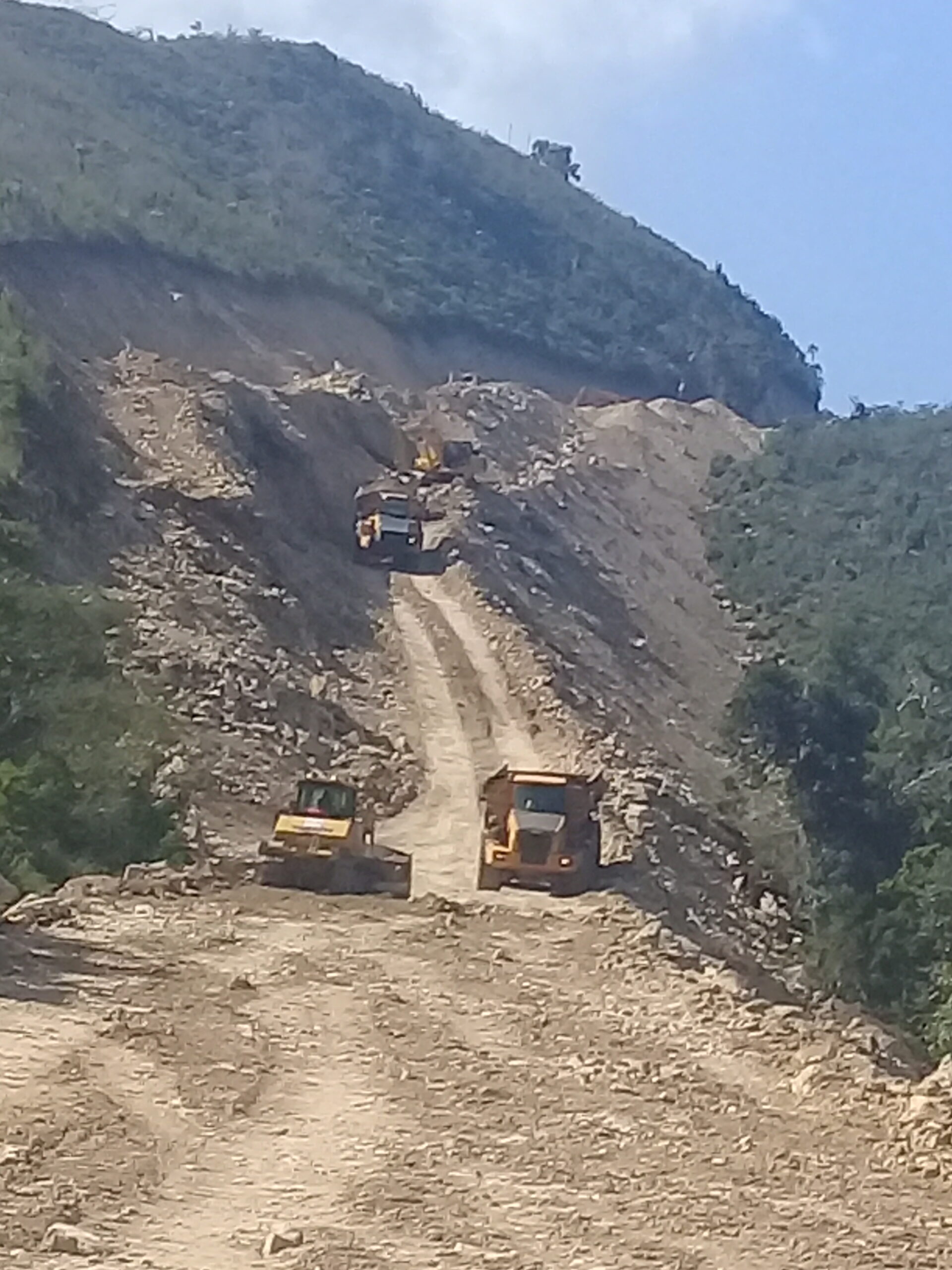 Obras civiles en ladera con maquinaria pesada y movimiento de tierra